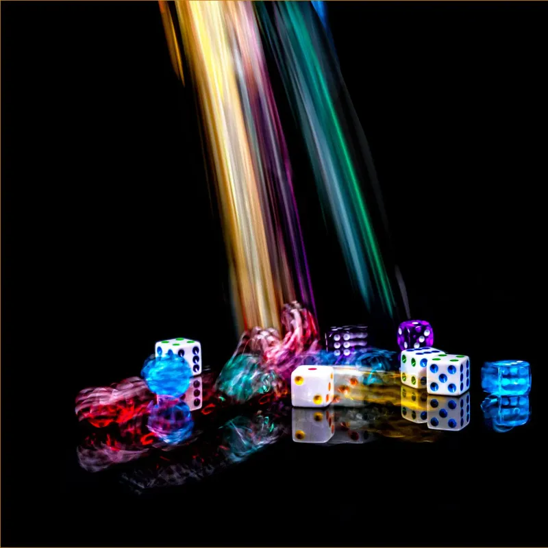 Colourful dice tumbling in streaks of light on a dark background
